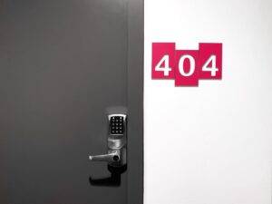 404 housing number sign with door and padlock on the left side.