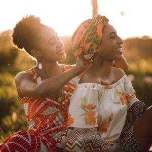 Woman helping another woman with her headpiece.